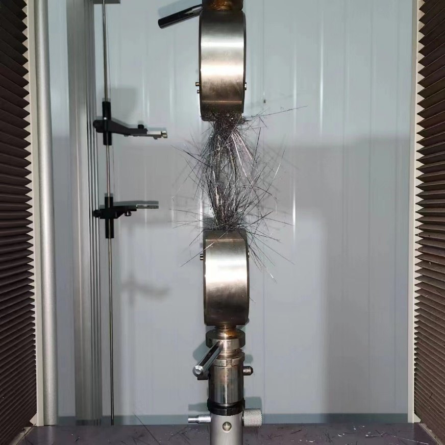 Carbon fiber specimen failing in tension on a universal testing machine